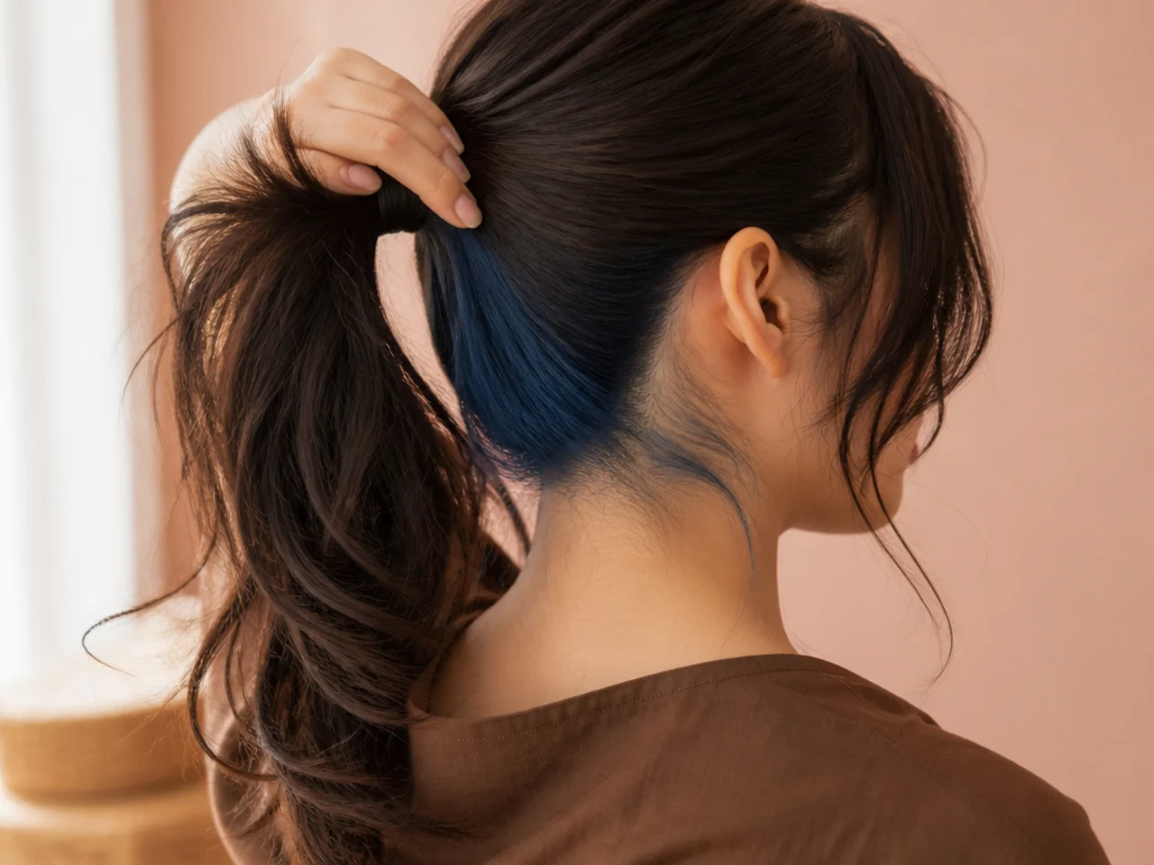 A blue panel at the nape revealed by a ponytail