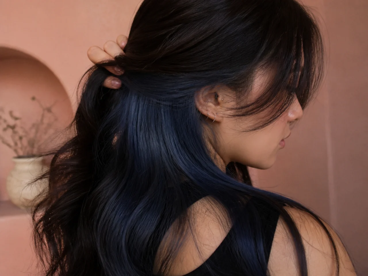 A blue black peekaboo panel catching the light under dark hair