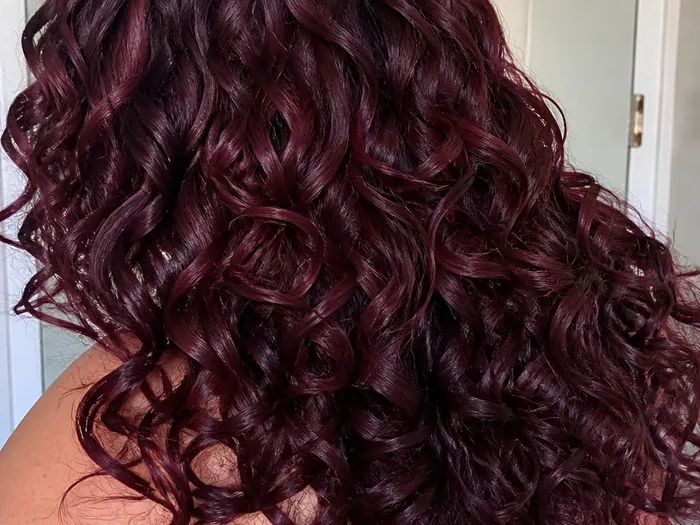 Cherry cola hair color on curly hair with dimensional shine