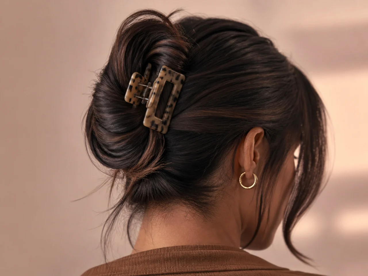 A clip passing through a coil into the hair beneath it