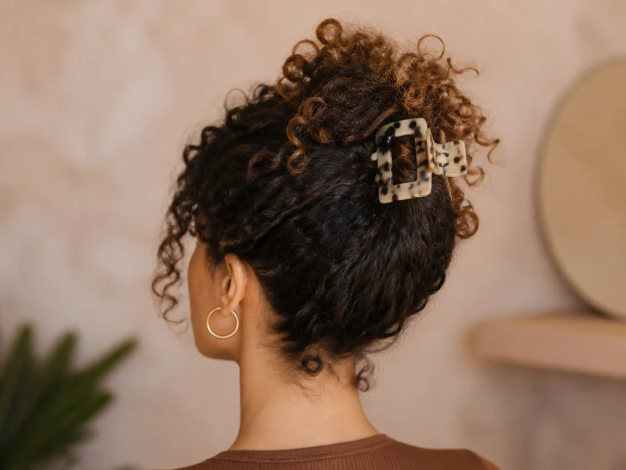 Curls gathered high in a pineapple with a clip
