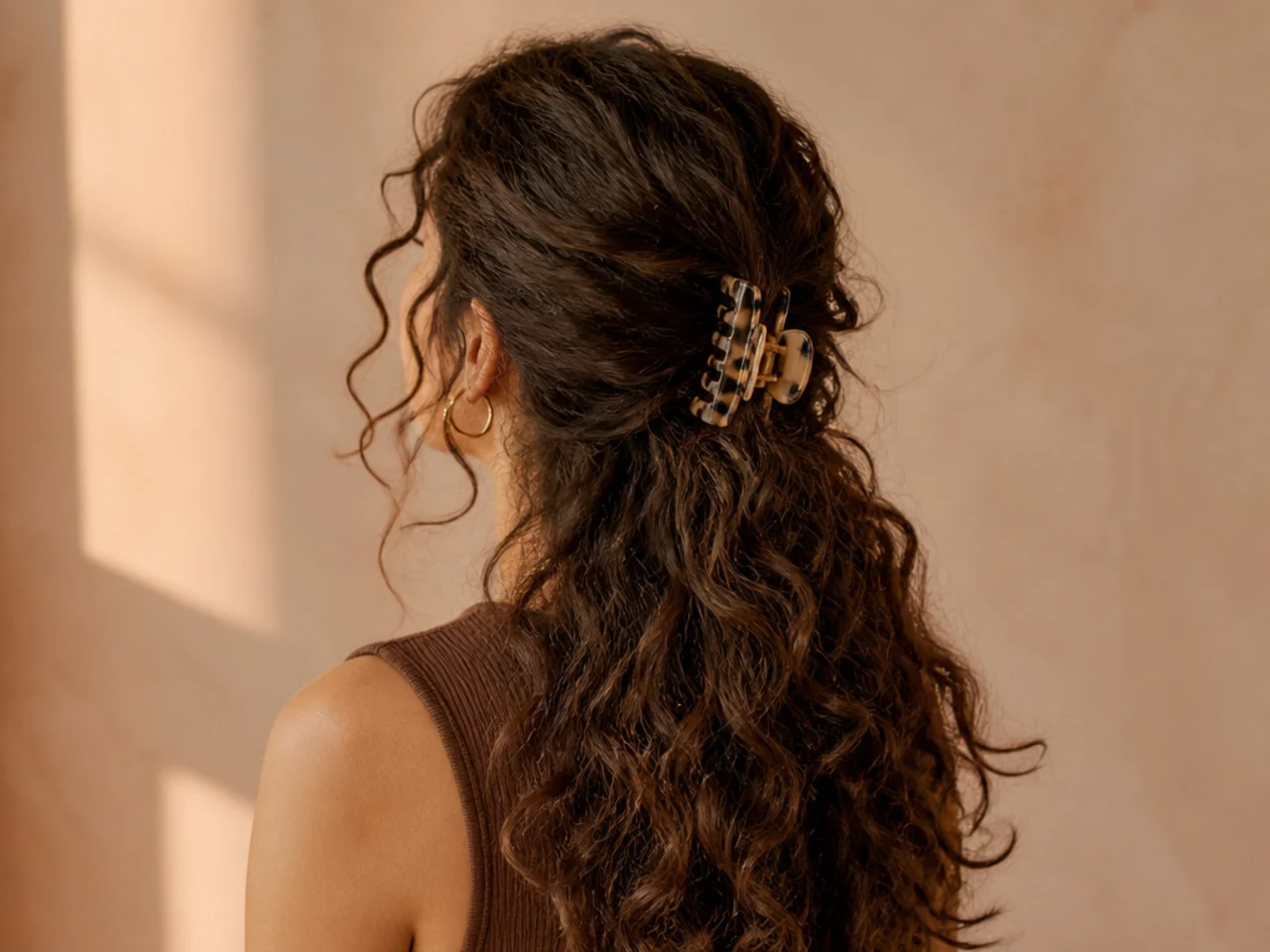 Long curly hair loosely gathered with a clip