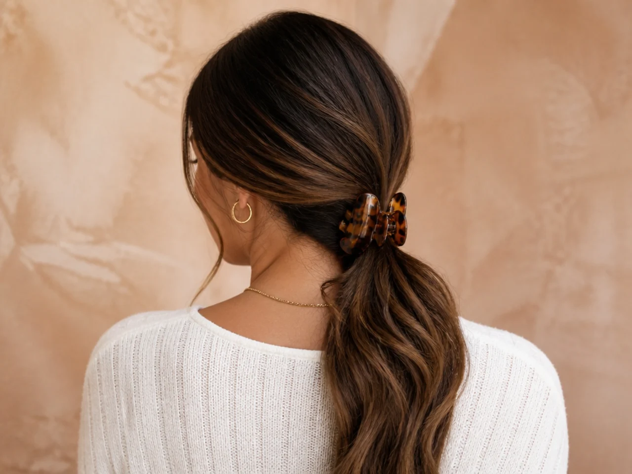 Long hair gathered low to one side and clipped