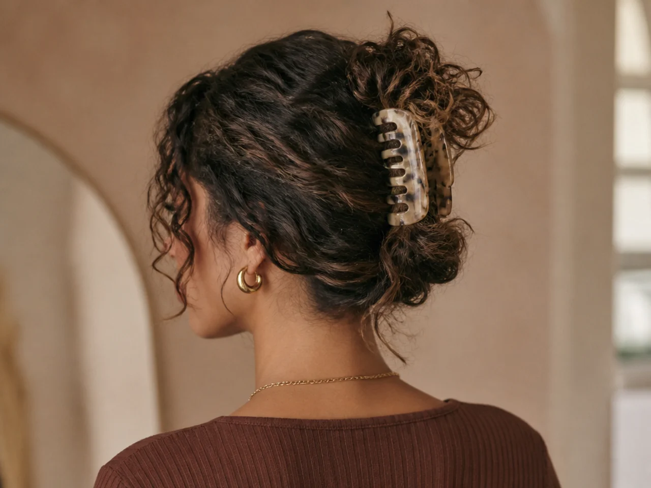 Curly hair loosely twisted into a claw clip
