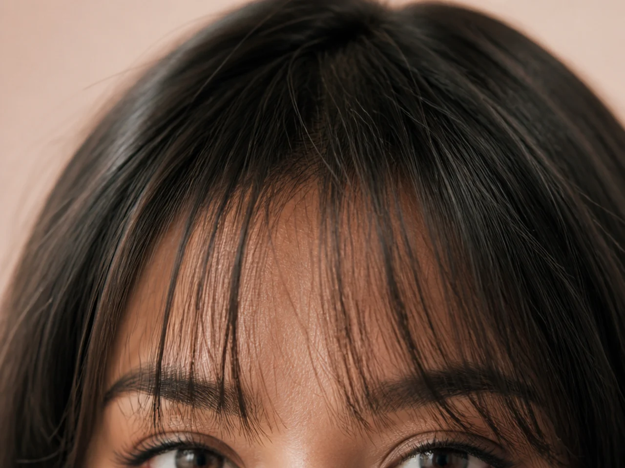 Close view of a fine hair fringe with visible forehead between the strands