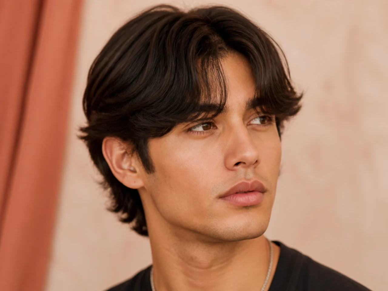 Full curtain bangs on a young man with thick straight brown hair — dense heavy fringe parted center with no forehead visible