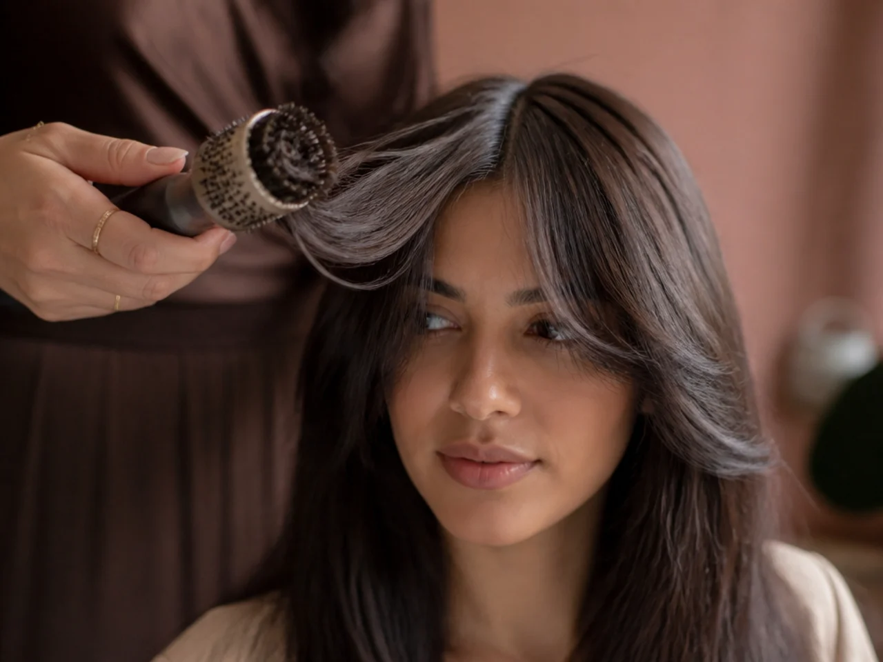 A round brush drying a fringe forward and outward from a centre part