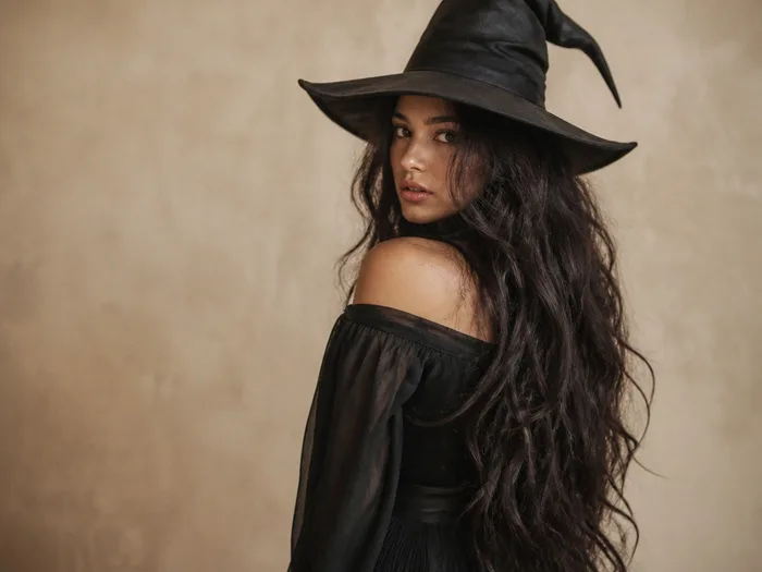 Long dark witchy waves under a wide-brim hat