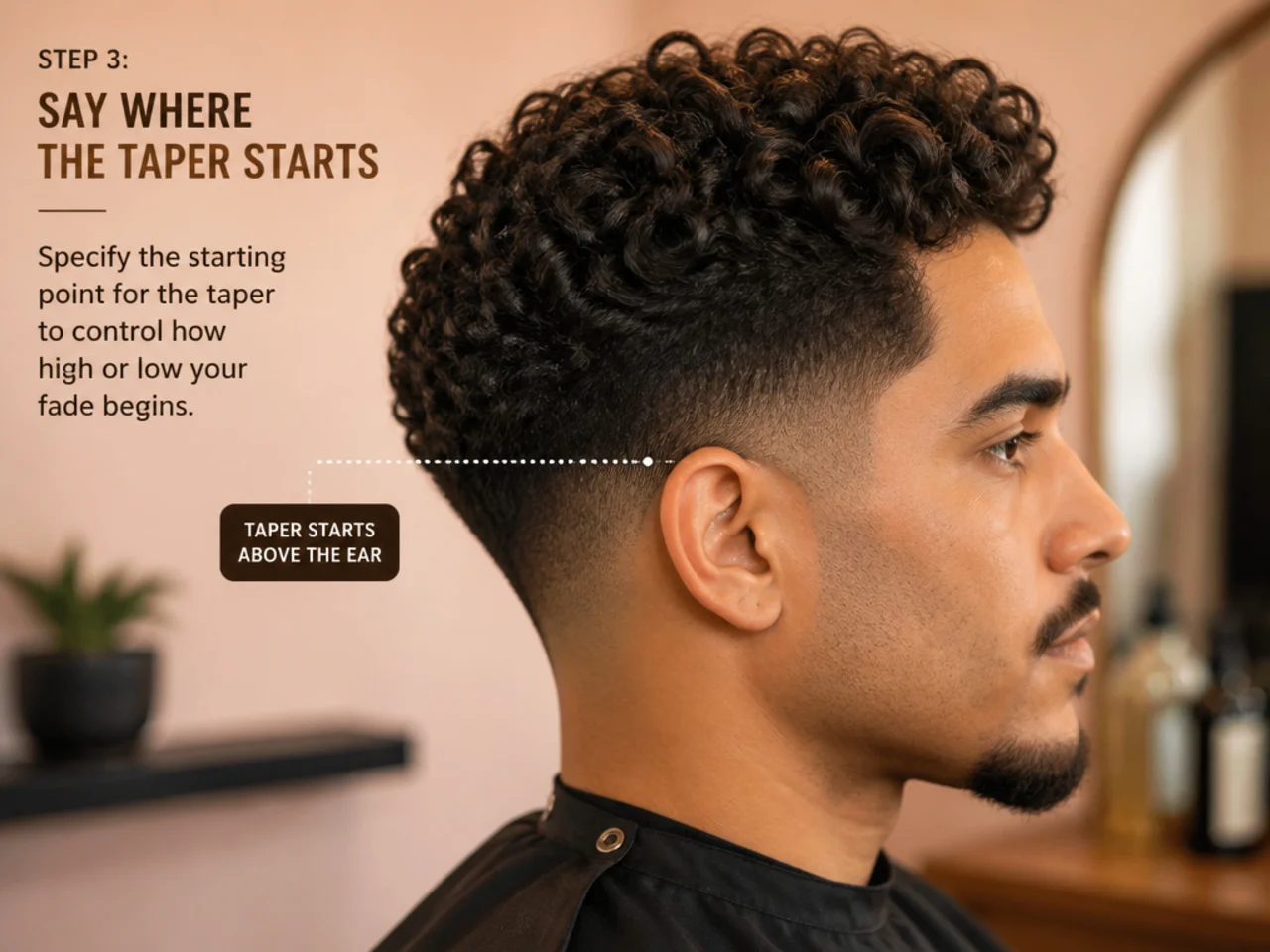 Barber pointing to the top of a client's ear to show where the low fade taper should begin