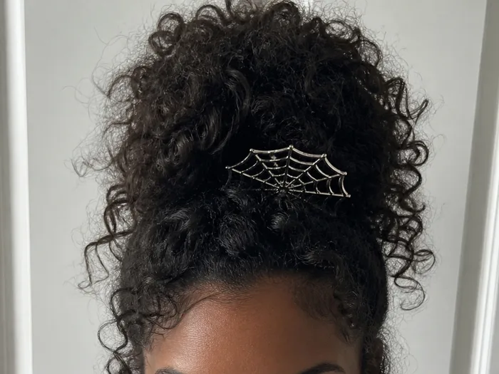 Spiderweb pineapple updo Halloween hairstyle with curls piled high and web detail