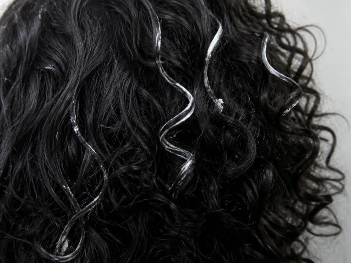 Skeleton curls Halloween hairstyle with white chalk streaks through dark curls