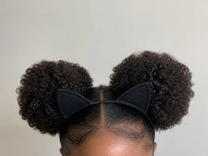 Cat-ear curly puffs Halloween hairstyle with two afro puffs and cat ears