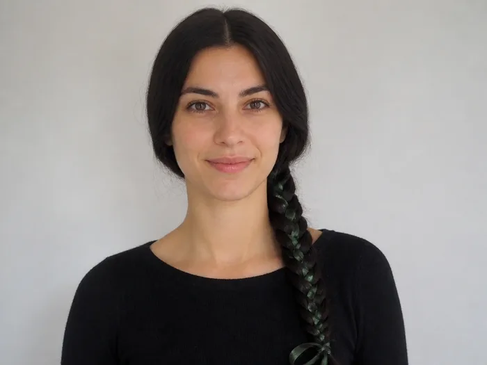 Long fishtail braid with green ribbon woven in, witchy Halloween hairstyle for long hair