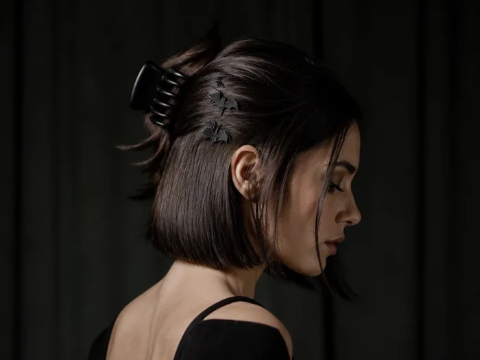 Bob styled back with a black claw clip and bat hair clips