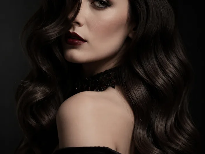 Sultry dark glossy waves with a deep side part for a vampire Halloween hairstyle