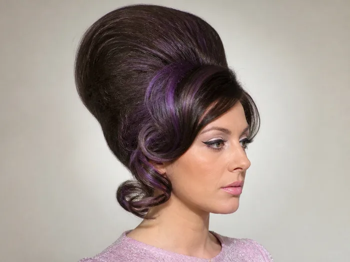 Gothic bouffant Halloween hairstyle with teased volume and purple streaks