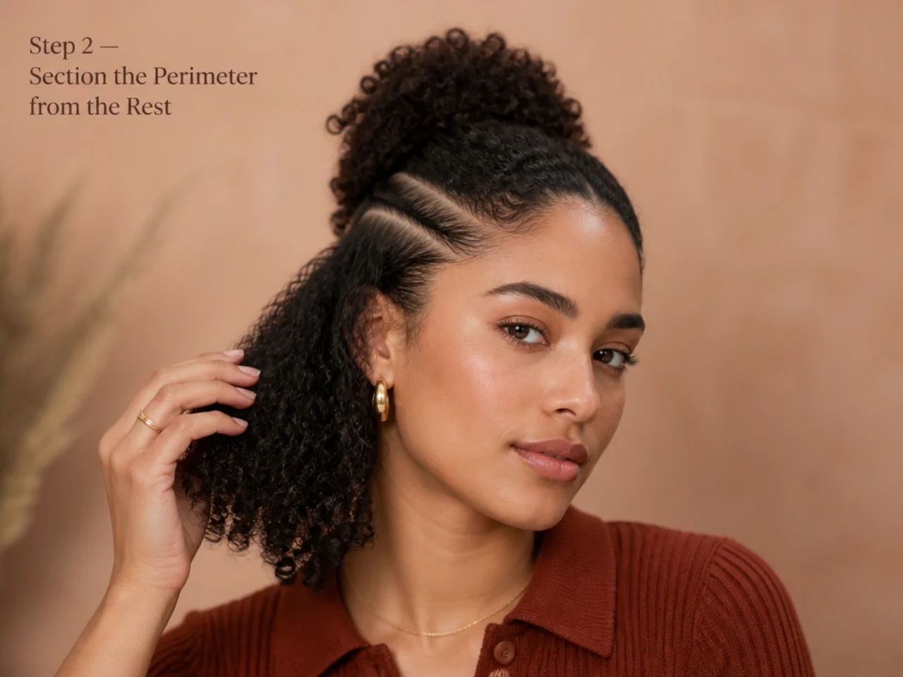 Rat-tail comb sectioning a two-finger band of perimeter hair on a Black woman with natural 4A hair