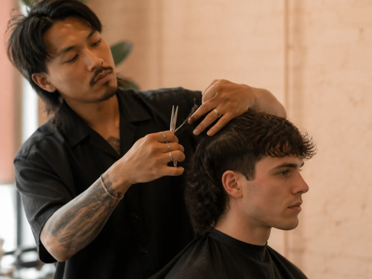 A barber layering the sides into the top of a mullet