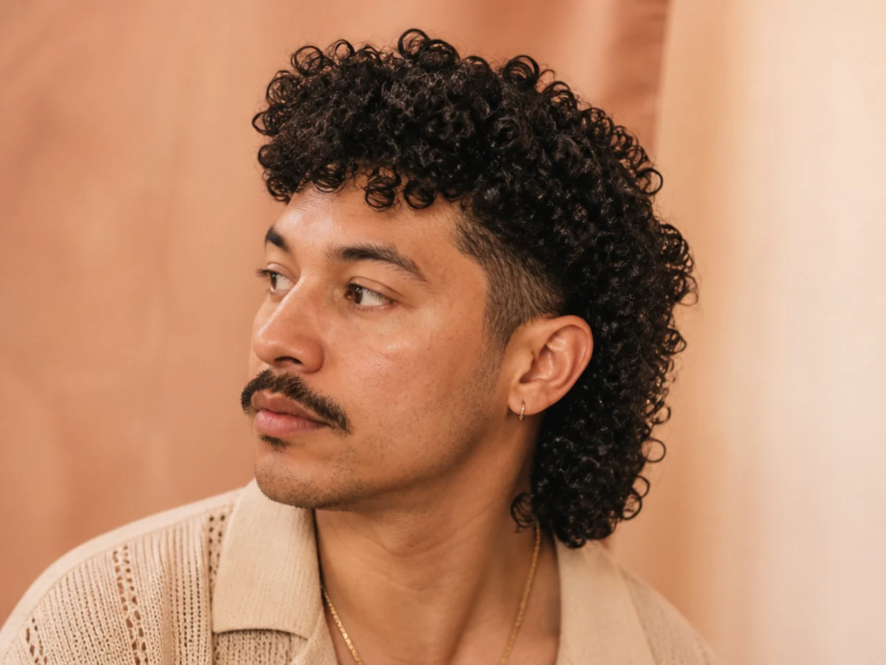 A coily textured mullet with a carefully shaped mustache