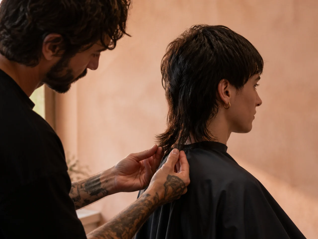 A barber checking length at the back of a mullet
