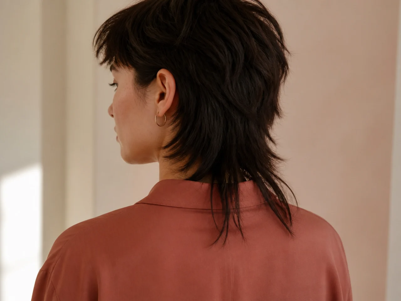A mullet tail measured against the shirt collar