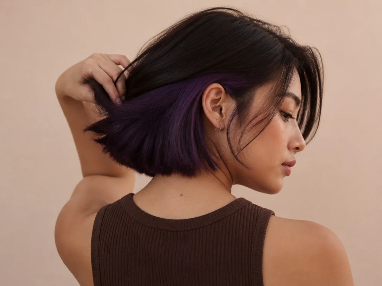 A deep violet panel under dark brown short hair