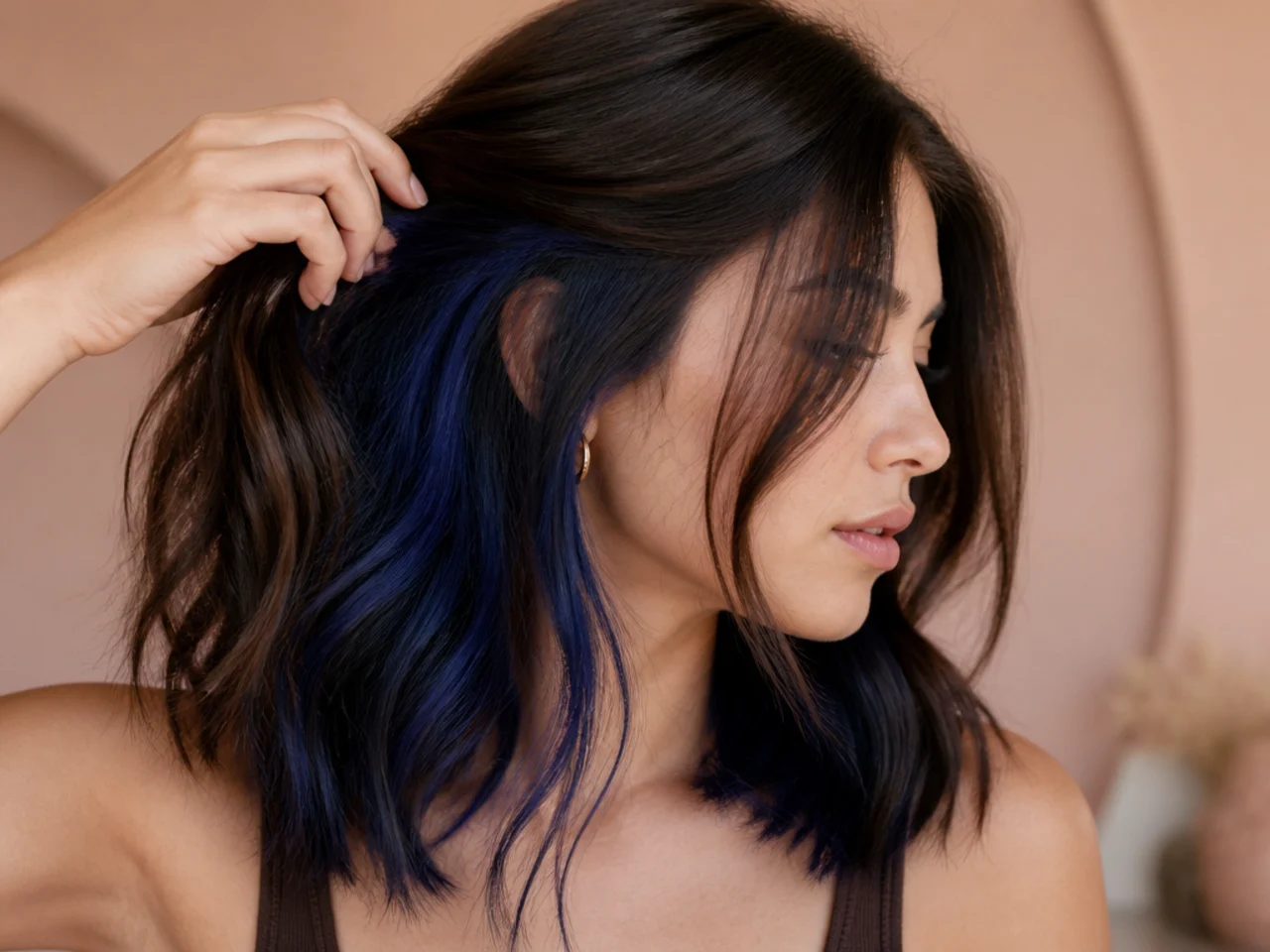 Dark brown hair with a midnight blue panel visible when the hair is lifted