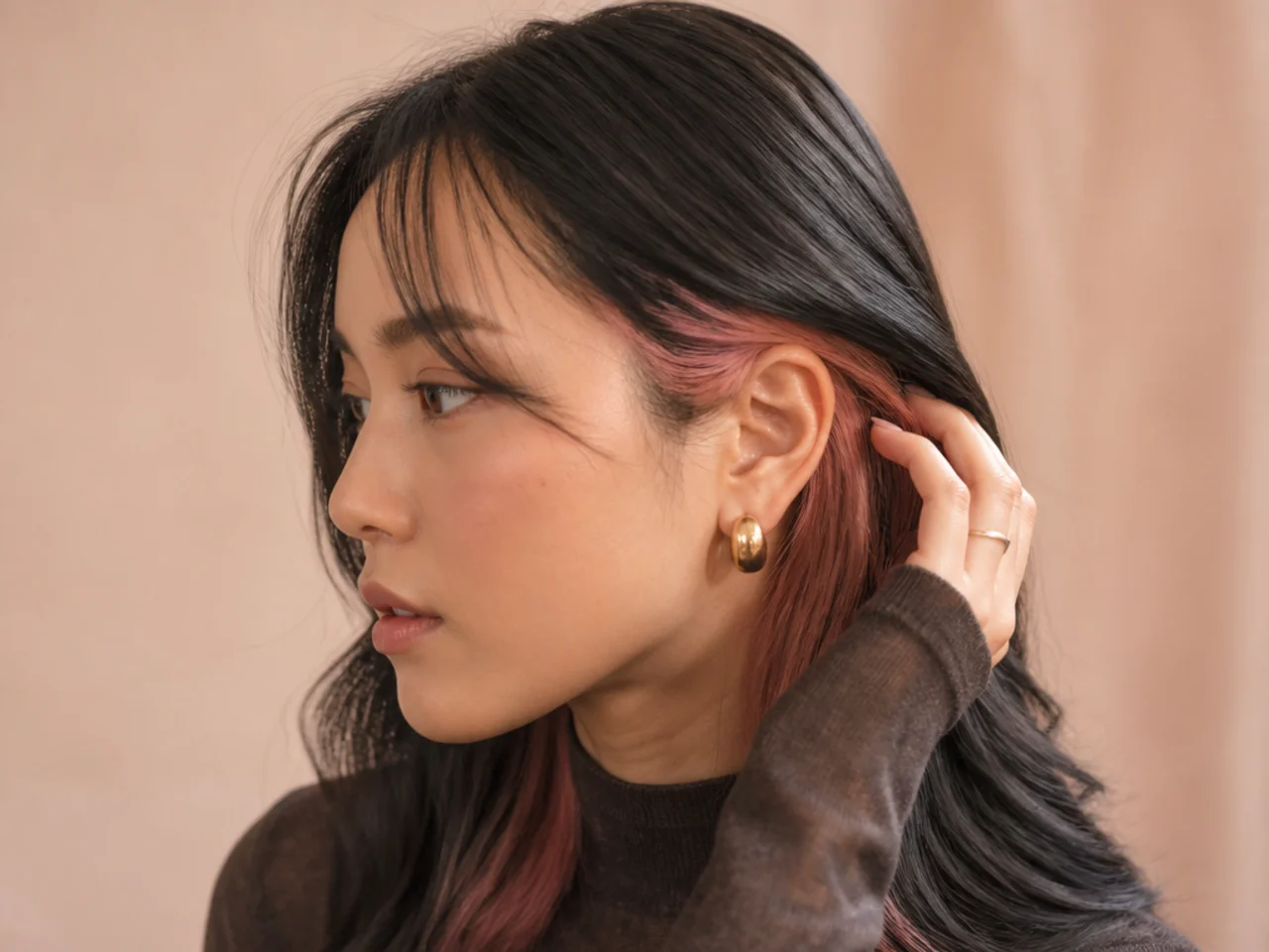 Pink showing at the side as hair is tucked behind an ear