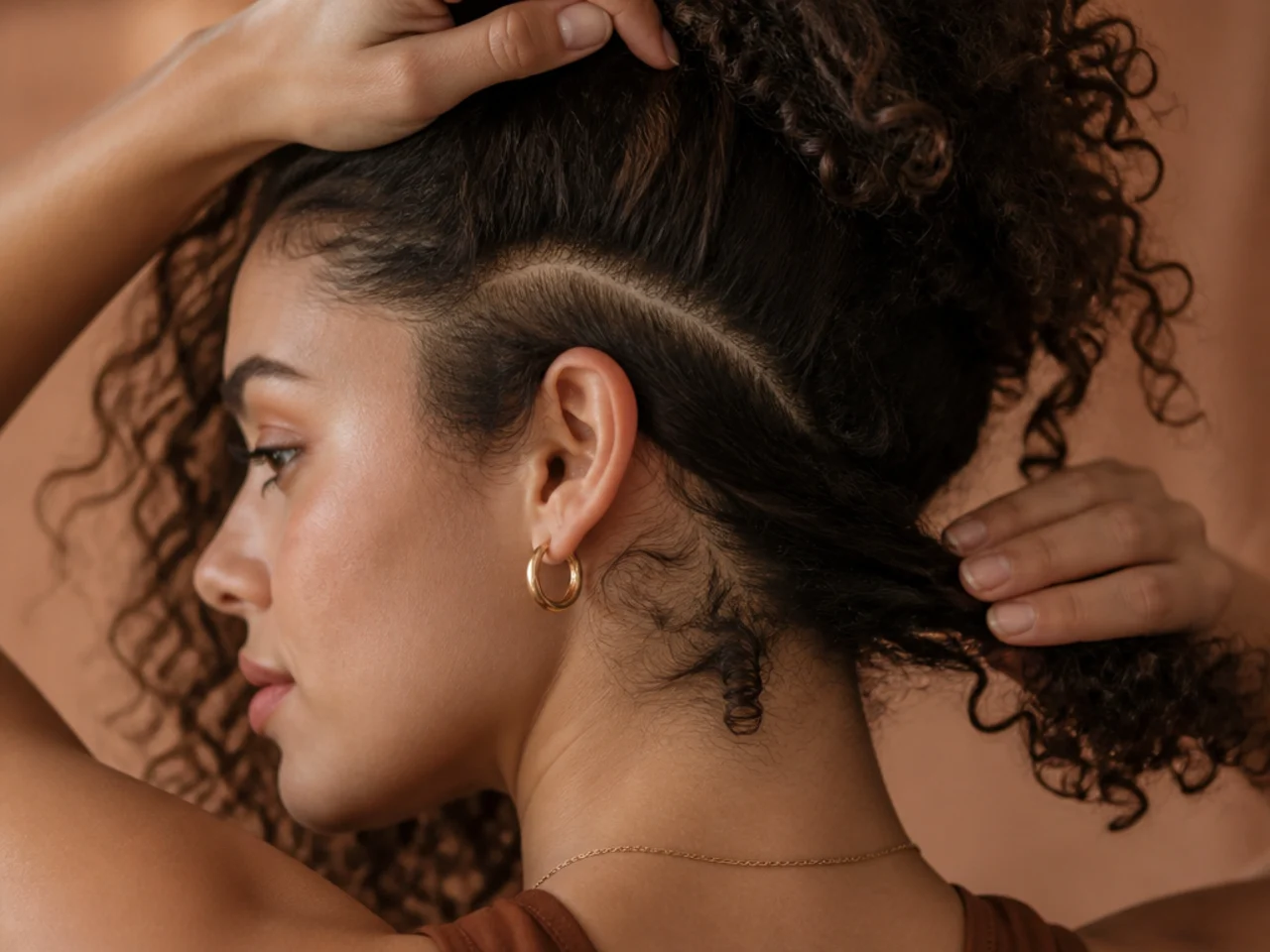 Curly hair sectioned into three marked panel placements, under the parting, behind the ear and at the nape