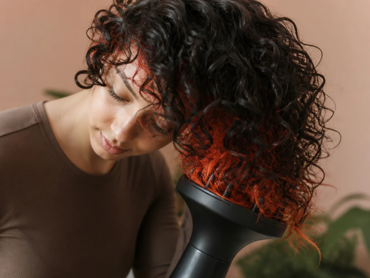 A diffuser drying a bright colored panel underneath a head of dark curls