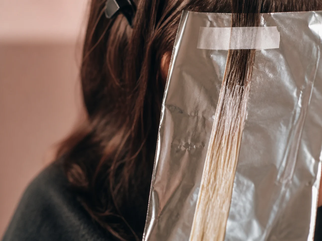 A small test strand of hair taped to foil after bleaching