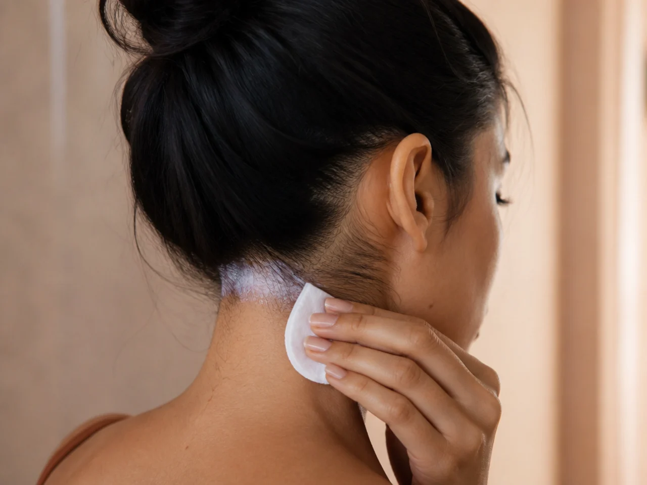 Barrier cream being wiped along the hairline at the nape