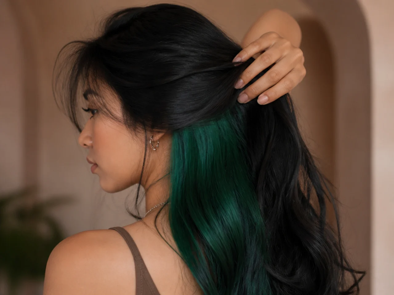 An emerald green underlayer on dark hair