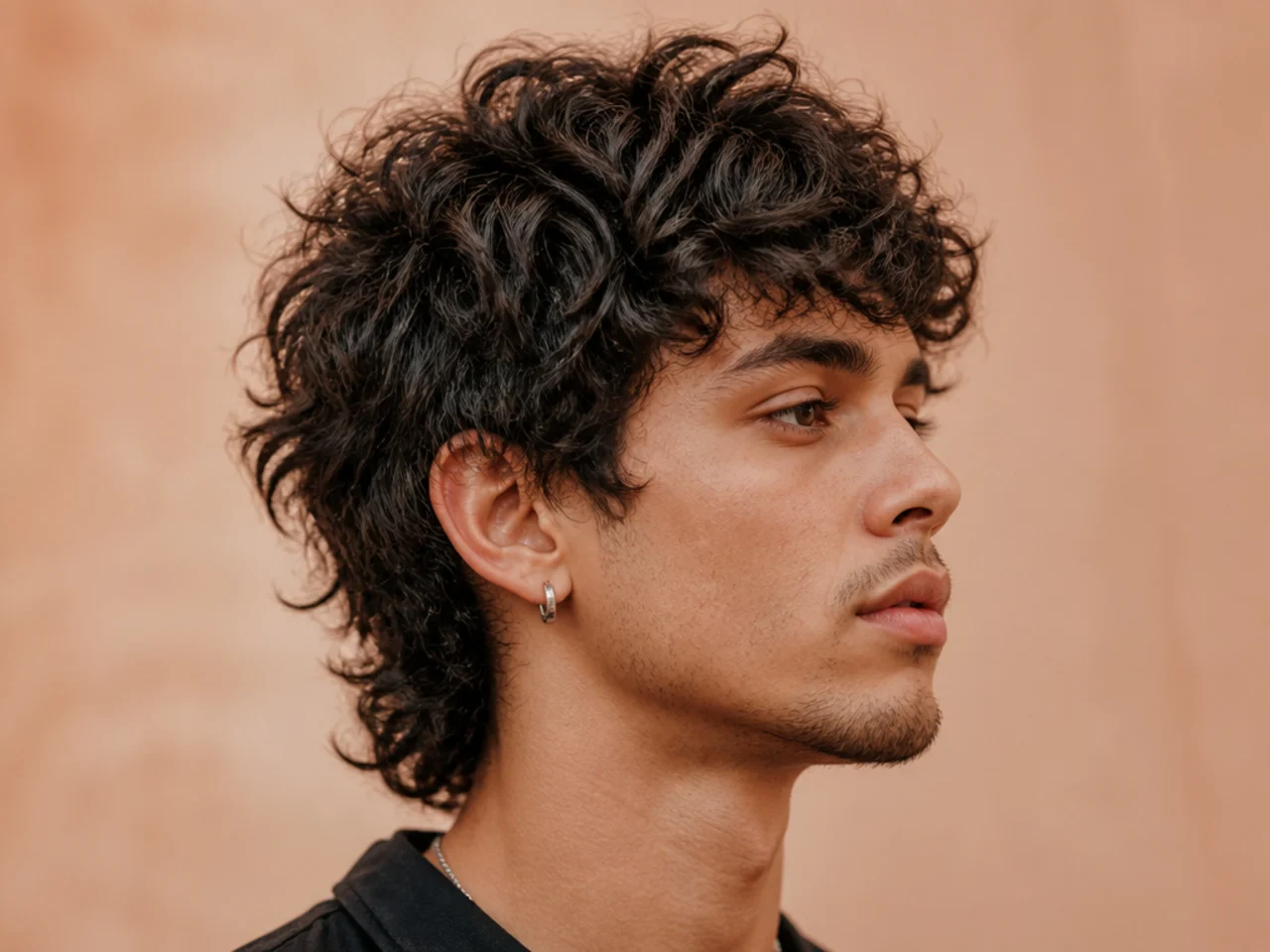 Short curly wolf cut on a man with type 3 curls in a defined layered shape
