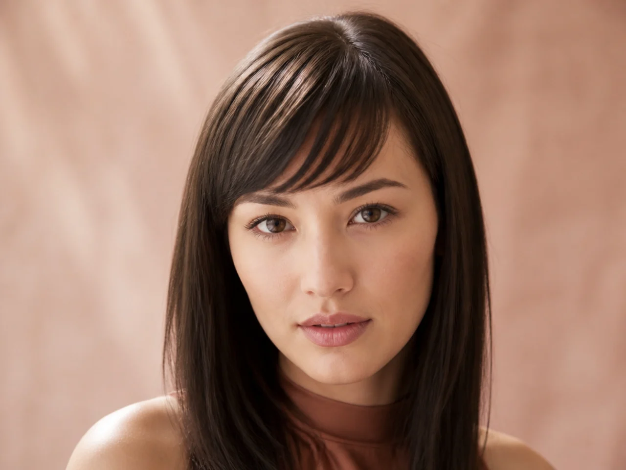 A fine fringe flattened against the forehead