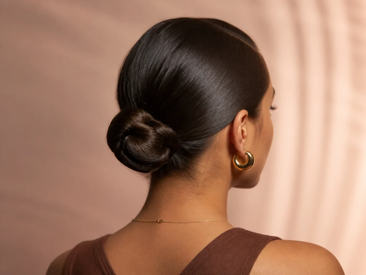 A sleek bun with a deep side part