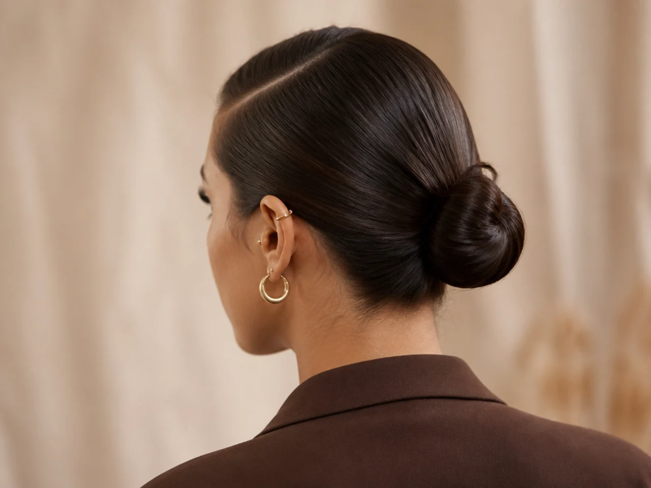 A slick back bun with a deep side part