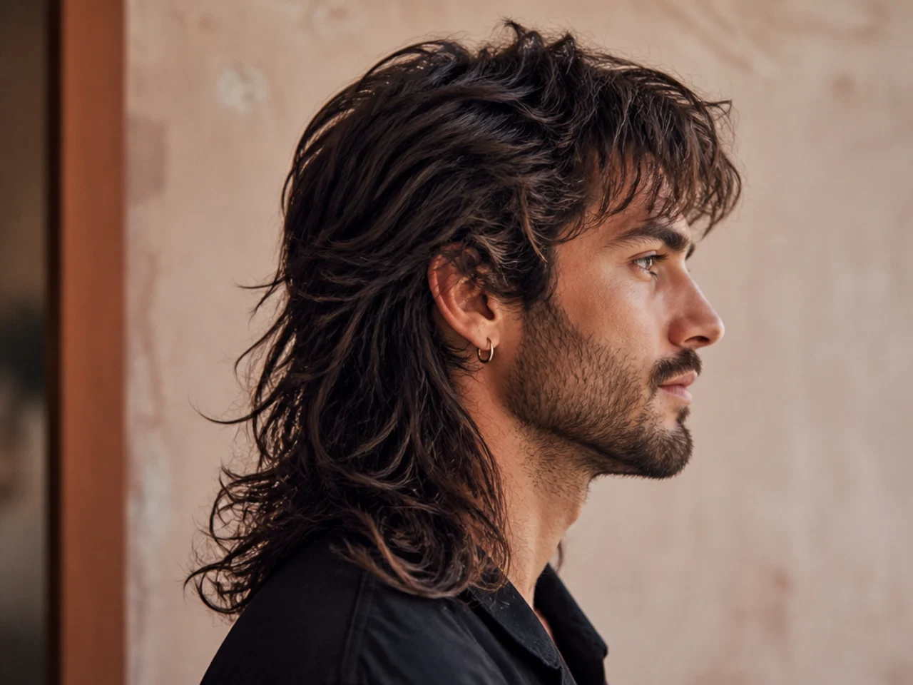 Long-layered rock mullet on a young man with heavily layered wolf top and a shoulder-length shag back on wavy dark hair