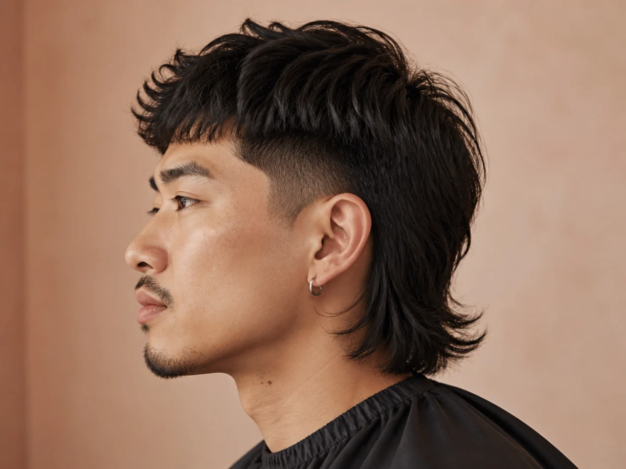 Two-block statement mullet on a young man with hidden two-guard clipper sides and a long layered top connecting to a mullet back