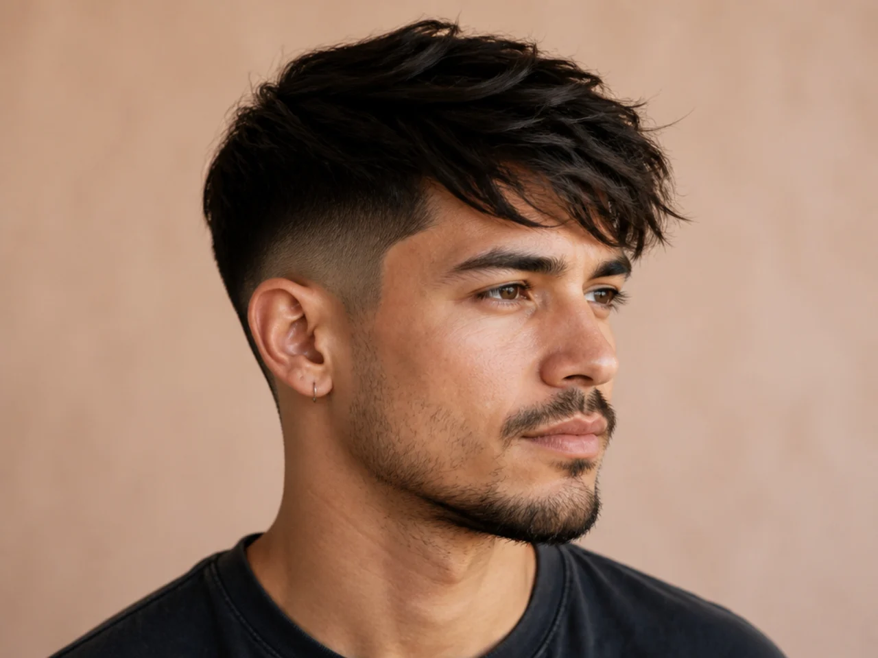 Side-swept textured fringe flowing diagonally across the forehead over a low taper fade