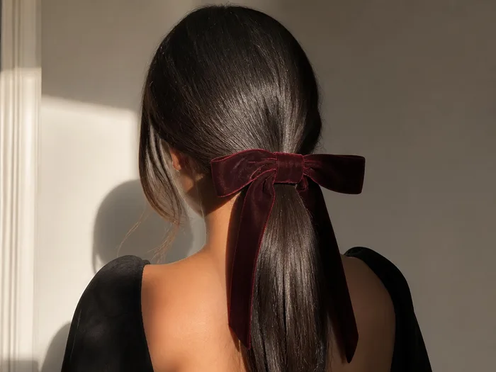 Sleek low ponytail Thanksgiving hairstyle with velvet bow