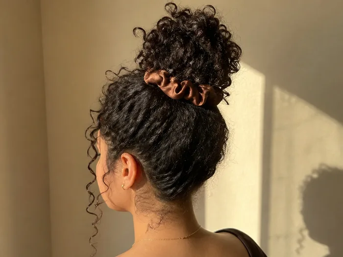 Curly pineapple updo Thanksgiving hairstyle with satin scrunchie
