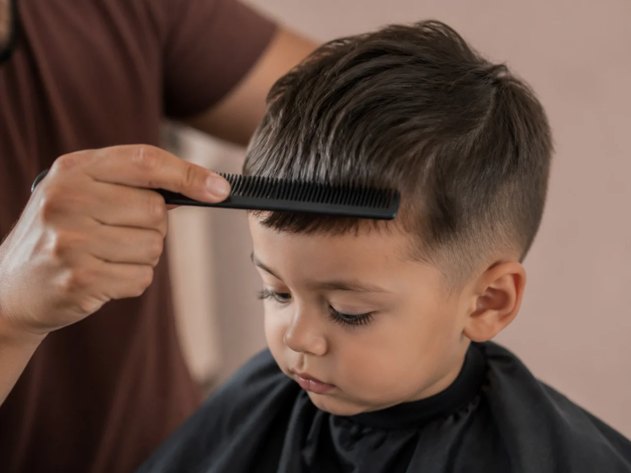 A parent combing a toddler's fringe down to check the length