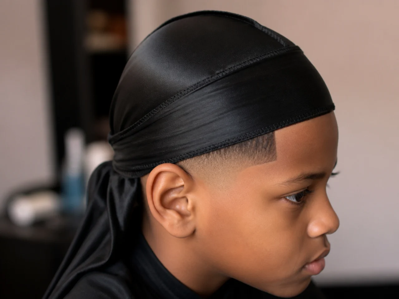 A boy wearing a durag over a fresh haircut