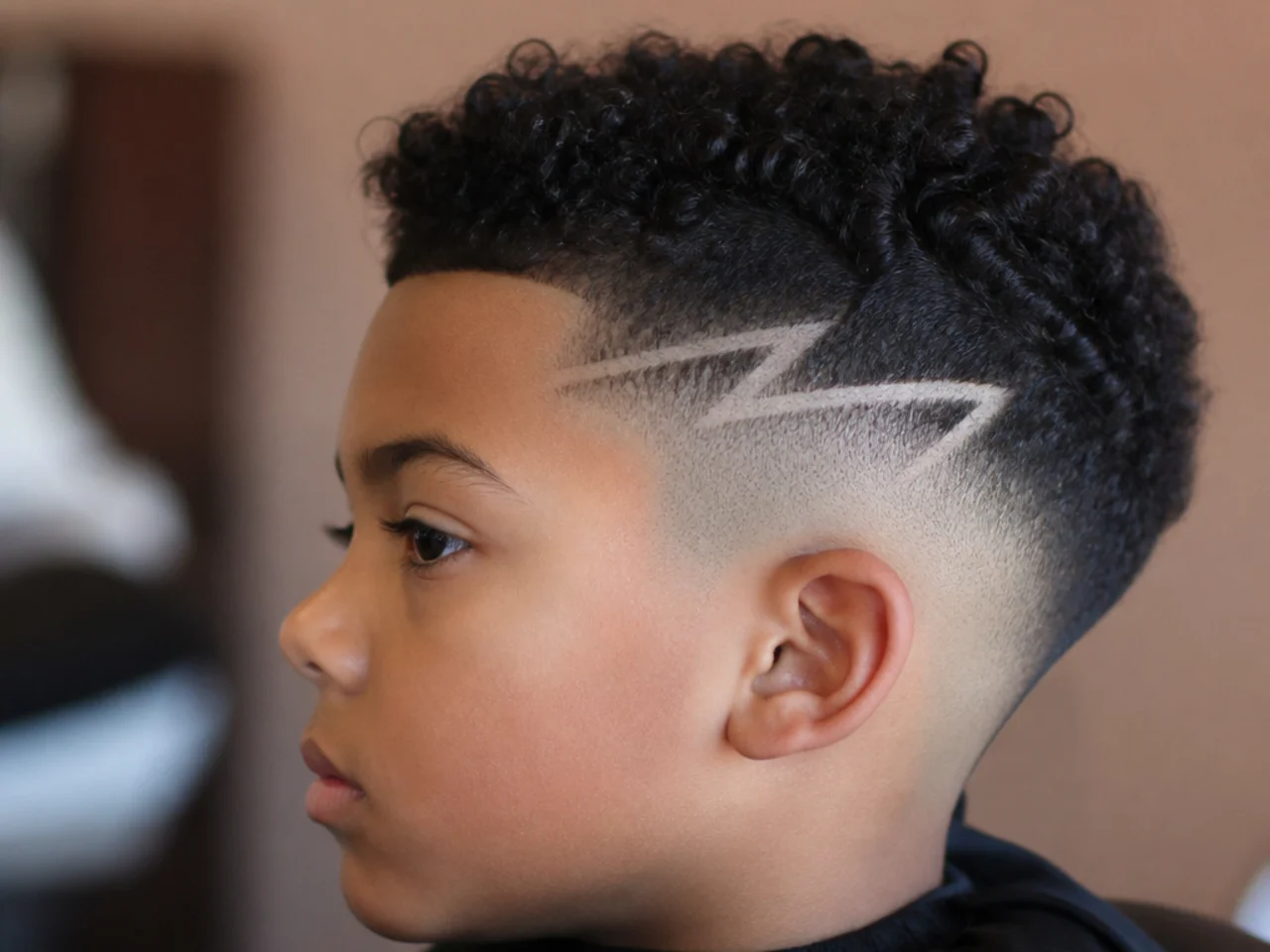 A young boy with a shaved design above a skin fade