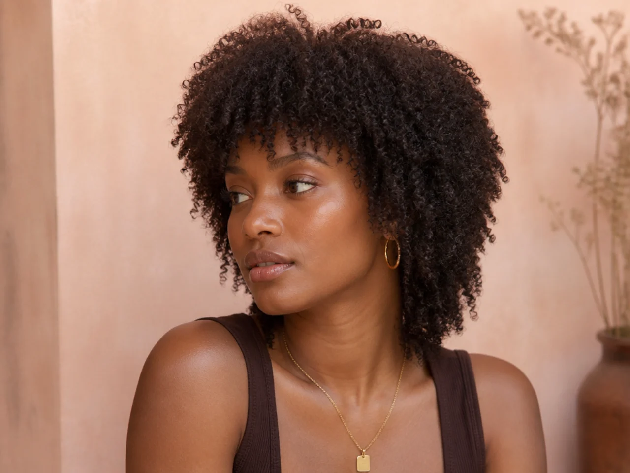 Fine coily hair in a lightly layered wolf cut with a full perimeter