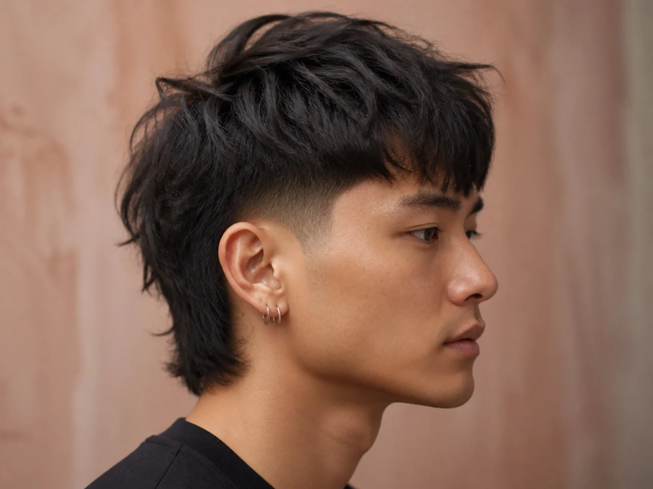 Wolf cut with low taper fade on straight hair, tight sides beneath layered mid-length top