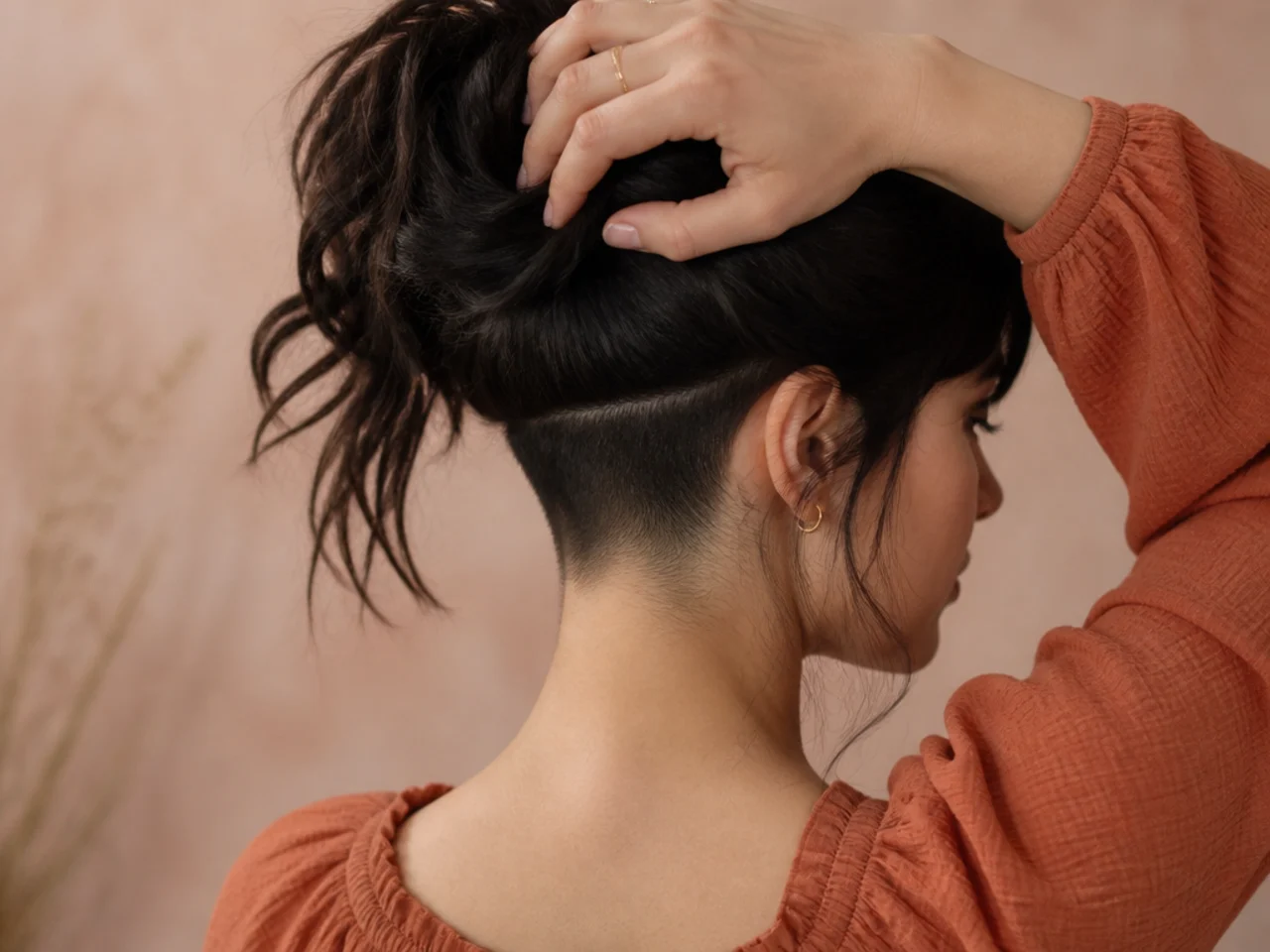 Hair lifted to reveal a shortened undercut section hidden at the nape