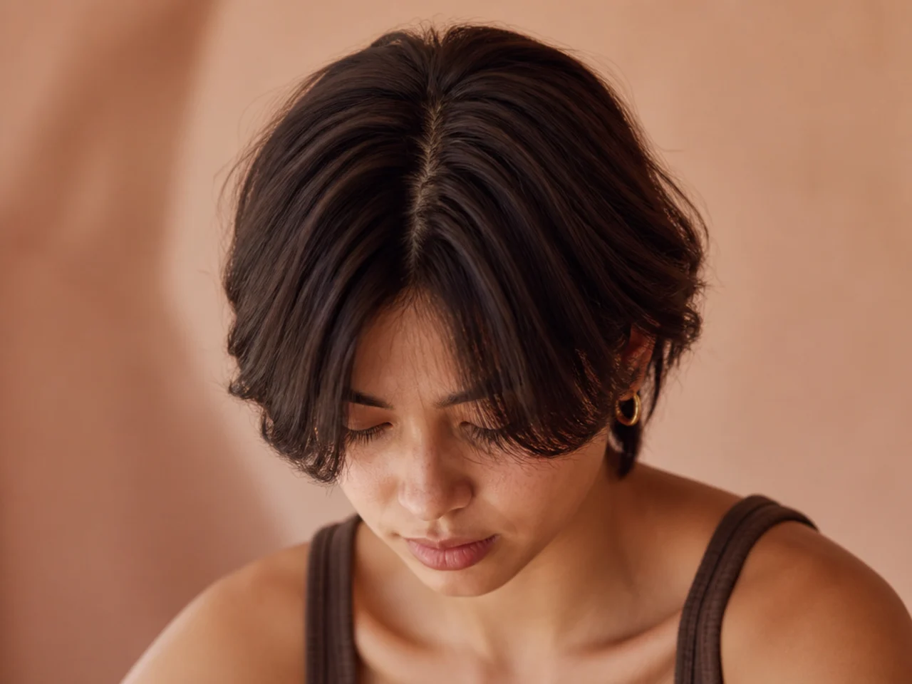 Short layered hair parted straight down the centre with both sides falling forward