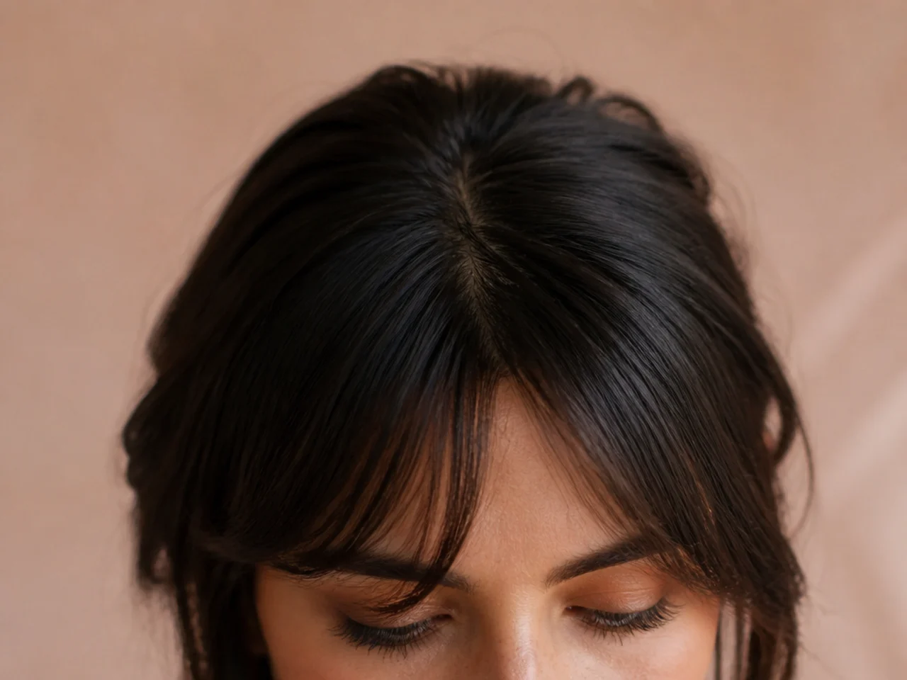A fringe splitting slightly at a cowlick near the front hairline